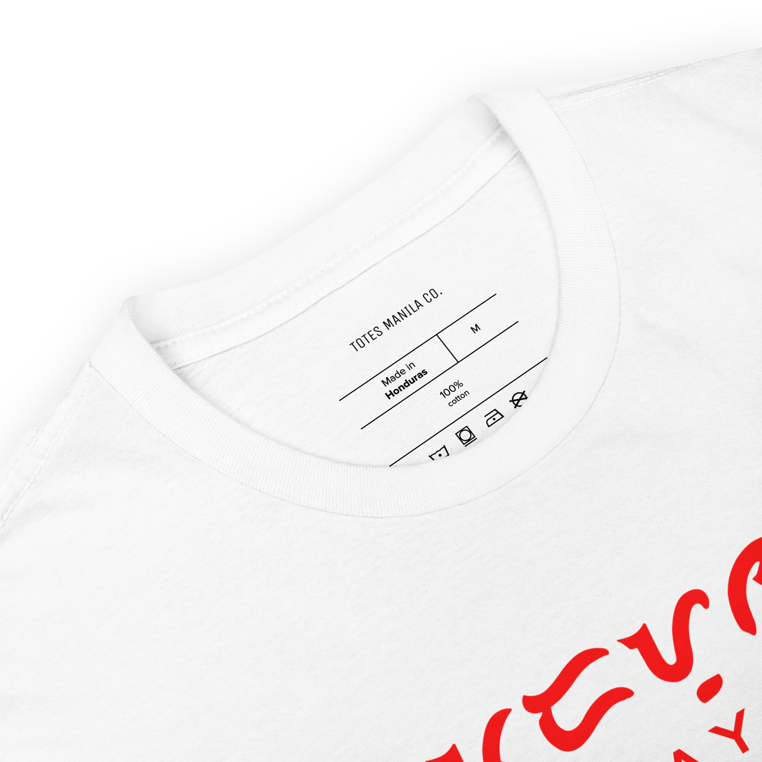 Totes Manila Co. label and shirt tag printed on the inside of a white unisex cotton shirt.