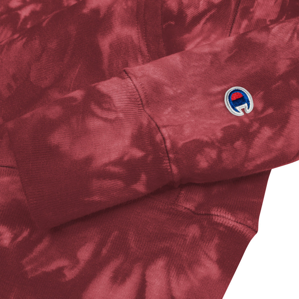 Close up of the Champion  logo, sleeves, and hem of a unisex tie-dye hoodie.