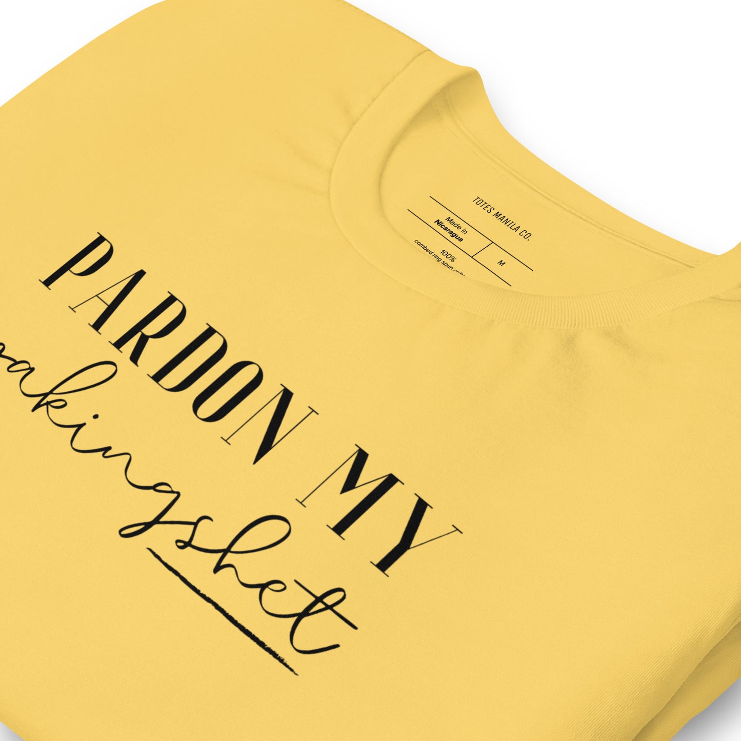 Close up of the Pardon My Pakingshet design printed on the center chest of a yellow shirt.